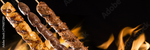Obraz na płótnie Assorted steak skewers on a fire background w salonie