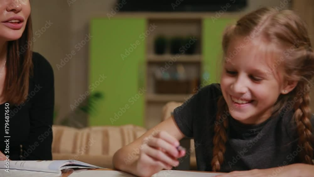 Mother and daughter doing a school homework assignment. Mom helps to deal with it. Mother and daughter doing a school homework assignment. Mom helps to deal with it.
