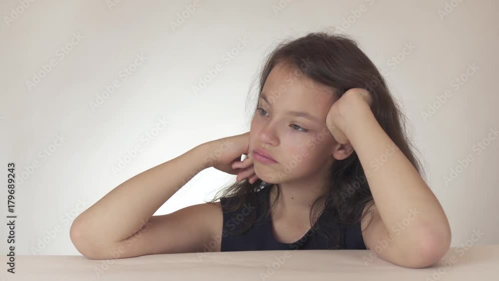 Beautiful sad teenage girl expresses resentment and sadness on white background stock footage video Beautiful sad teenage girl expresses resentment and sadness on white background stock footage video