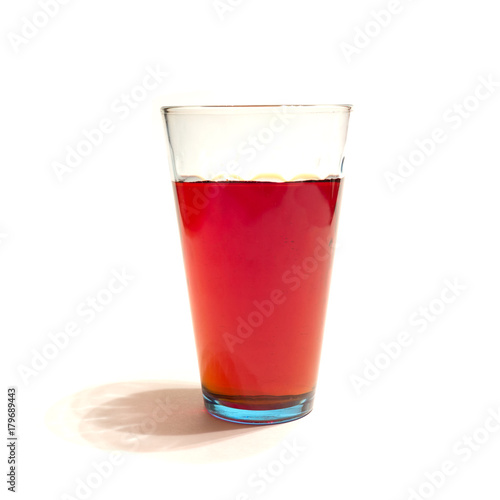 red juice in a glass on a white background, isolate