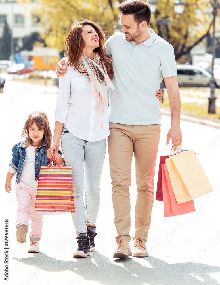Family walking along the street with shopping bags Family walking along the street with shopping bags