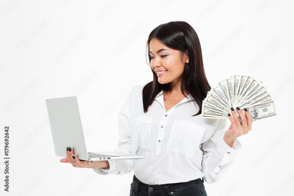 Happy young asian woman holding money using laptop computer. Happy young asian woman holding money using laptop computer.