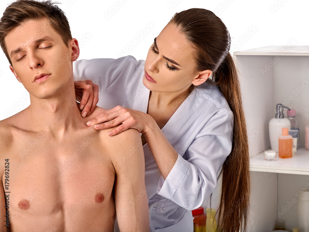 Shoulder and neck massage for man in spa salon. Doctor making neck therapy in rehabilitation center on isolated. Repositioning of the joint in the clinic. Correction of posture.