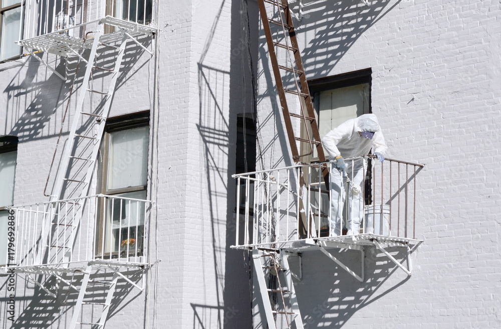 Building painter painting metal fire escapes white