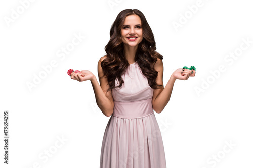 Sexy woman in a chic gently pink dress holding colored poker chips. Woman winning photo
