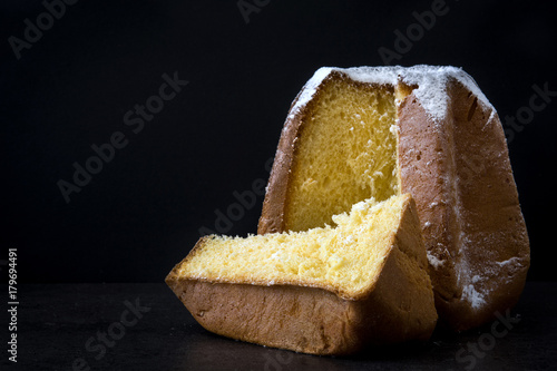 Pandoro Christmas cake with sugar on black background.Copyspace