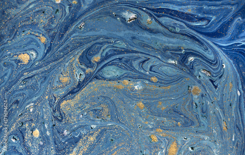 Marbled blue abstract background with golden sequins. Liquid marble ink pattern. © anya babii