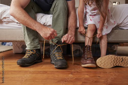 Dad teaching his daughter how to tie shoelaces, low section