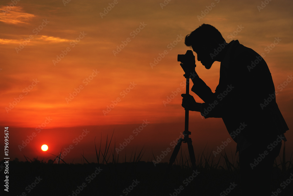 Silhouette man take photo on sunset.