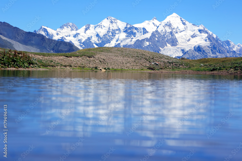 the Caucasus mountain range in the reflection of the mountain lake.