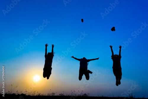 silhouette of children jumping on the prairie at yellow evening horizon sea yellow sunset heaven background outdoor.