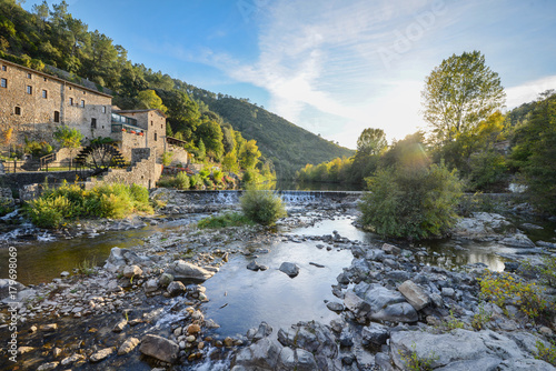 beautiful and colorful river mountain autumn fall season landscape with a watermill at sunset photo