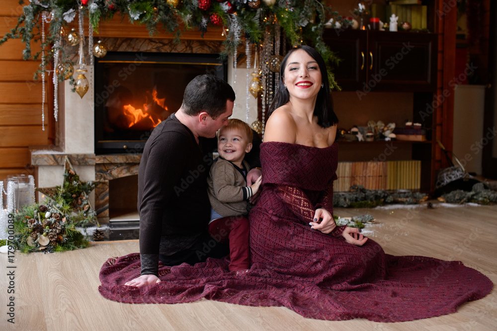 Happy family near the fireplace with New Year's decorations. Merry Christmas. Happy New Year.