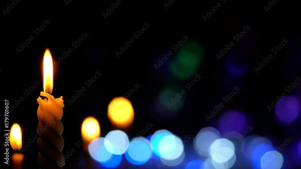 Candle lit in front of festive lights Christmas
Candle lit in front of festive lights Christmas
