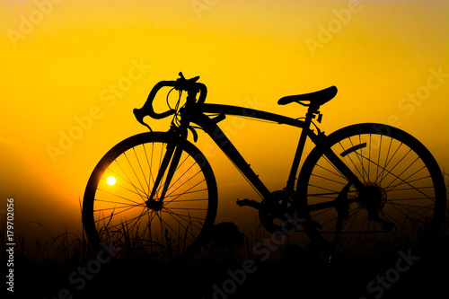 Silhouette bicycle on sunset. © Anek