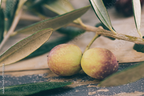 Olive branch with green olives on a wooden table photo