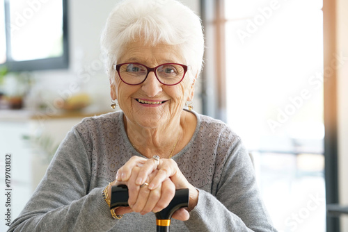 Portrait of smiling old woman holding cane photo