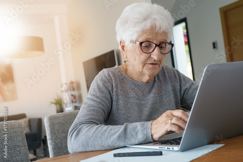 Old woman at home using laptop computer