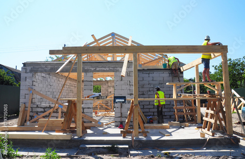 Roofers Building Wood Trusses Roof Frame House Construction. Roofing construction with wooden beams frame and terrace roof truss.