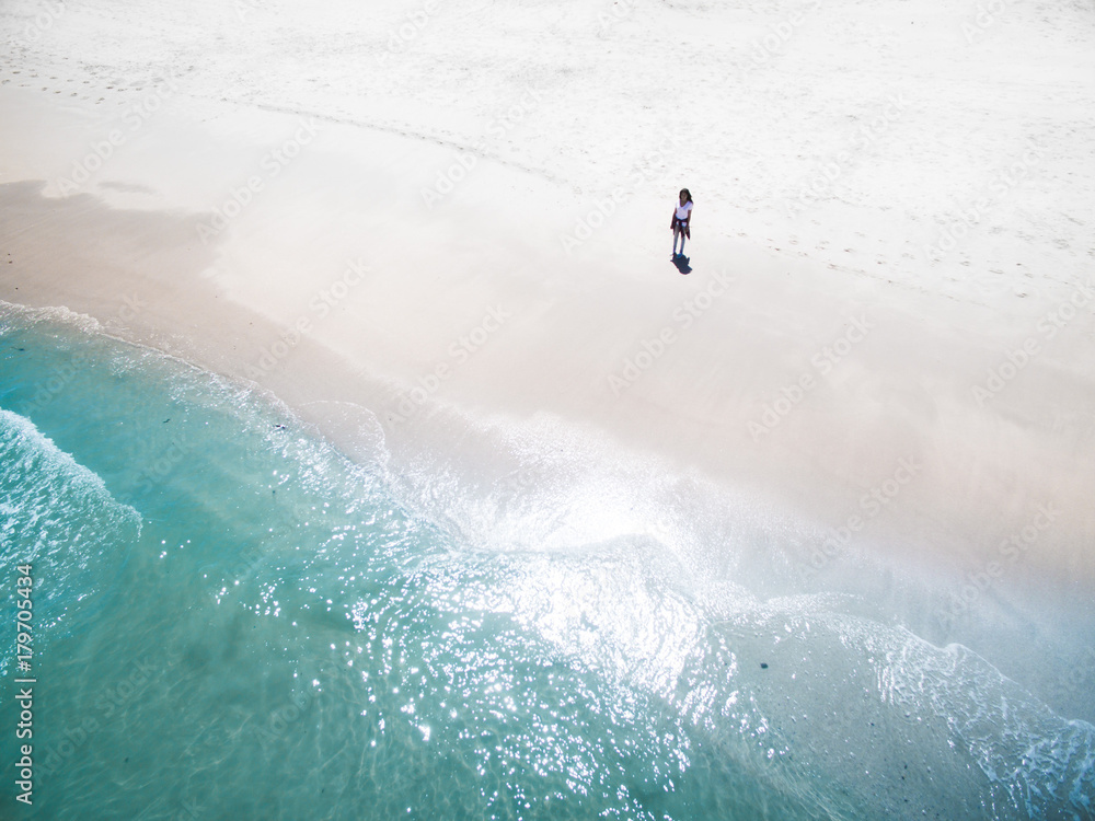 Naklejka premium Woman standing on beach shore alone