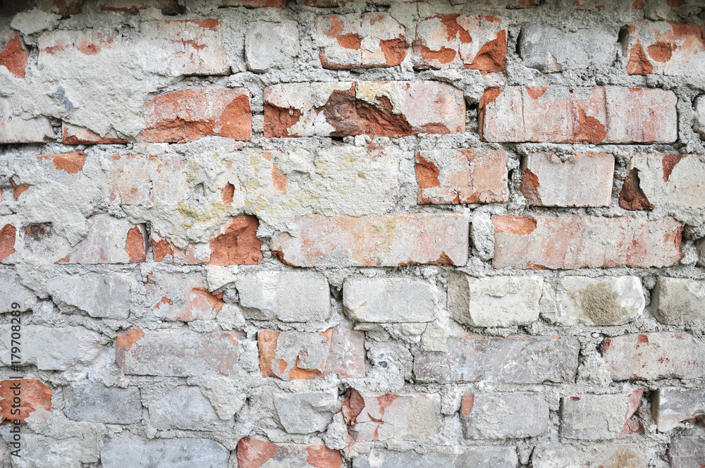 rough red brick wall after the removal of the facade , with the remnants of cement and plaster rough red brick wall after the removal of the facade , with the remnants of cement and plaster