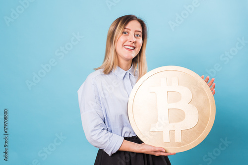 Funny woman holding a Golden Bitcoin. virtual money.