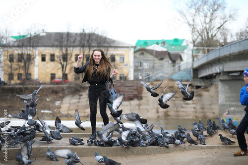 Girl on a walk in the park and a flock of pigeons