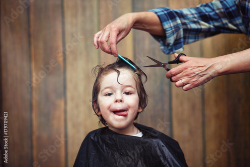 A little boy is trimmed in the hairdresser's 