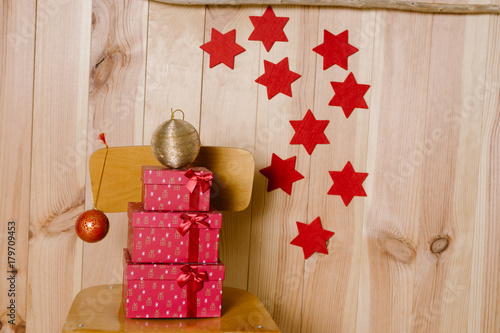 Quadro su tela Regalos de navidad sobre fondo de madera y estrellas rojas