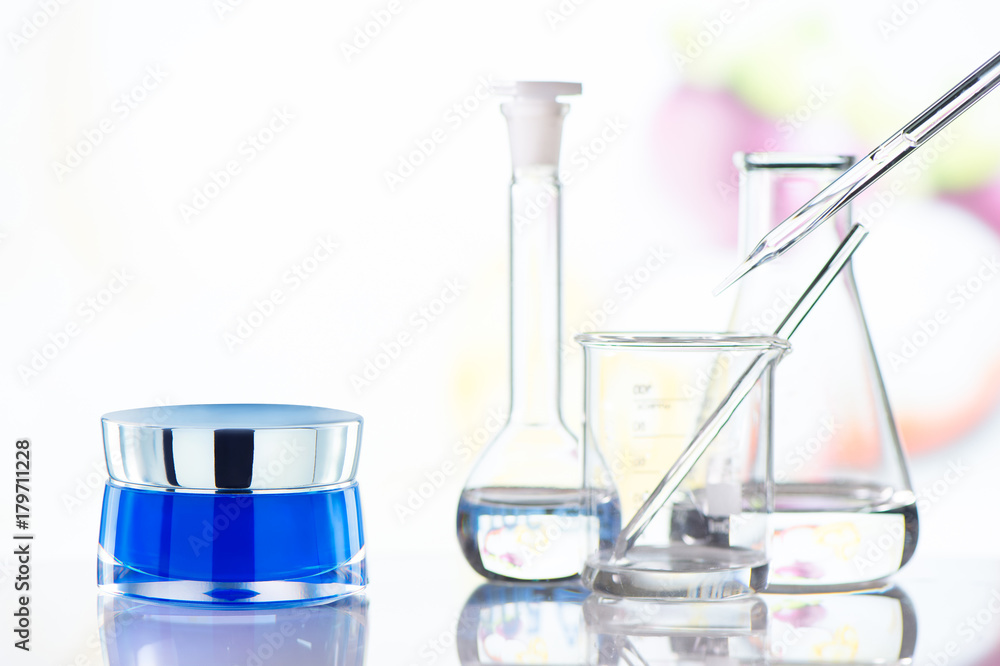 Cream jar with science glass on glass table. Front view. Cream jar with science glass on glass table. Front view.