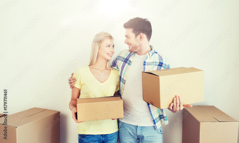 smiling couple with big boxes moving to new home smiling couple with big boxes moving to new home