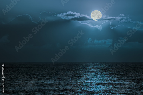 Fotografia Blue moon light reflecting off ocean. Romantic twilight moonlight