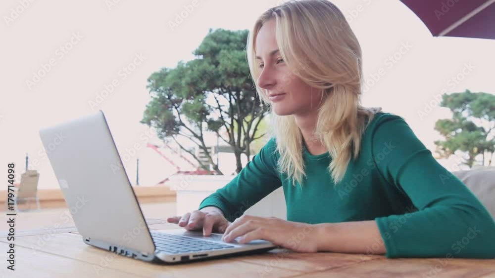Close-up of young professional businesswoman using her laptop outside.