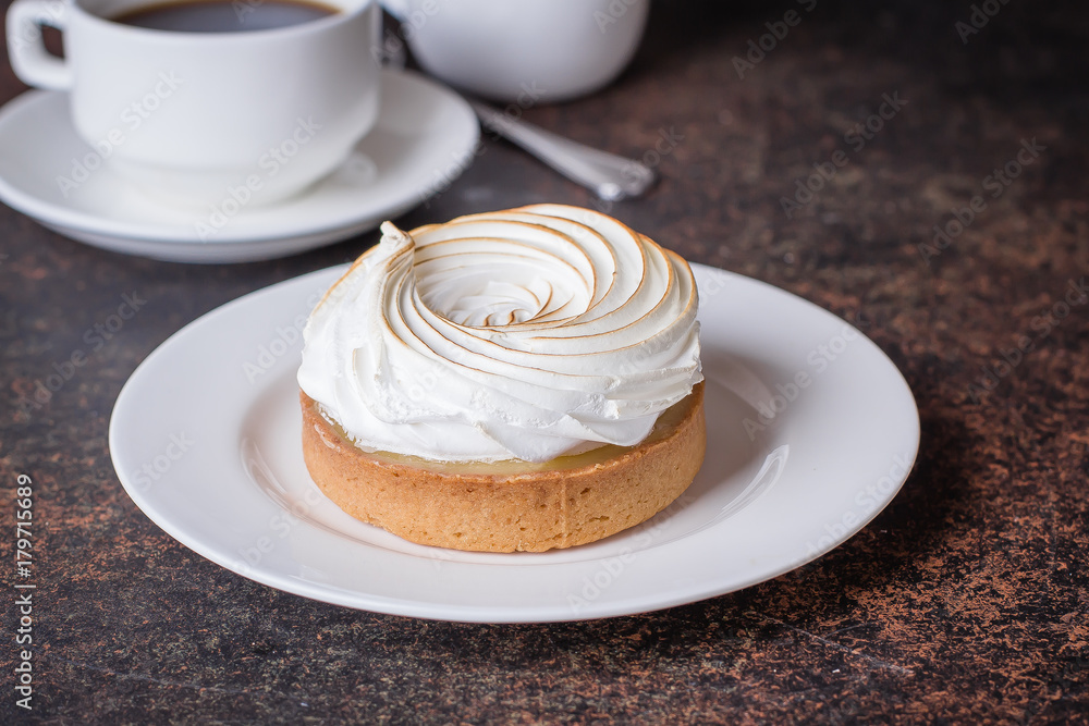 Delicious Lemon tart tartlet with meringue and cup of hot coffee on dark stone concrete table background. Copy space Delicious Lemon tart tartlet with meringue and cup of hot coffee on dark stone concrete table background. Copy space