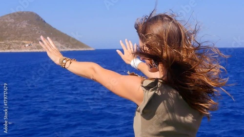 A young woman admires the sea from the deck of a ship. photo