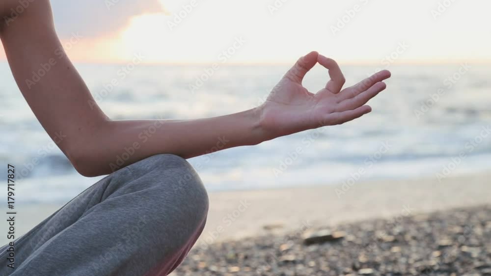young beautiful woman is having meditation near the sea: practicing yoga. young beautiful woman is having meditation near the sea: practicing yoga.