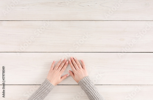 Woman hands on white rustic wood, top view