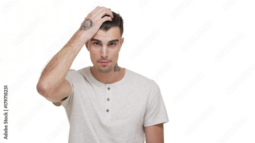 horizontal portrait of tense brunette man with tattoo on body clutching his head being nervous stressed thinking about solution of problem over white background closeup. Concept of emotions horizontal portrait of tense brunette man with tattoo on body clutching his head being nervous stressed thinking about solution of problem over white background closeup. Concept of emotions