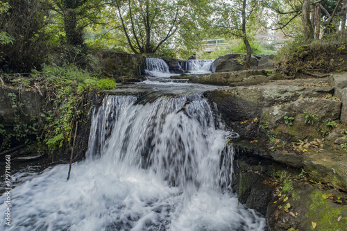 Waterfall in a river between rocks and trees 
