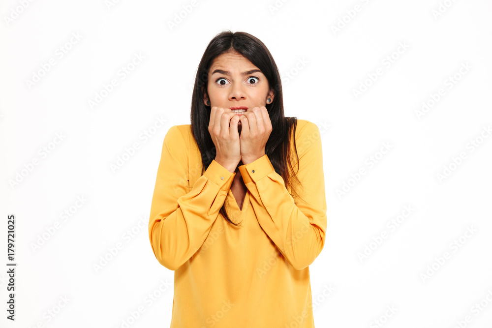Shocked scared young lady in yellow shirt standing isolated Shocked scared young lady in yellow shirt standing isolated