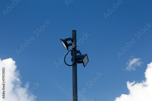 Photo of spotlight with a bright blue sky is the background.