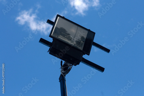 Photo of spotlight with a bright blue sky is the background.