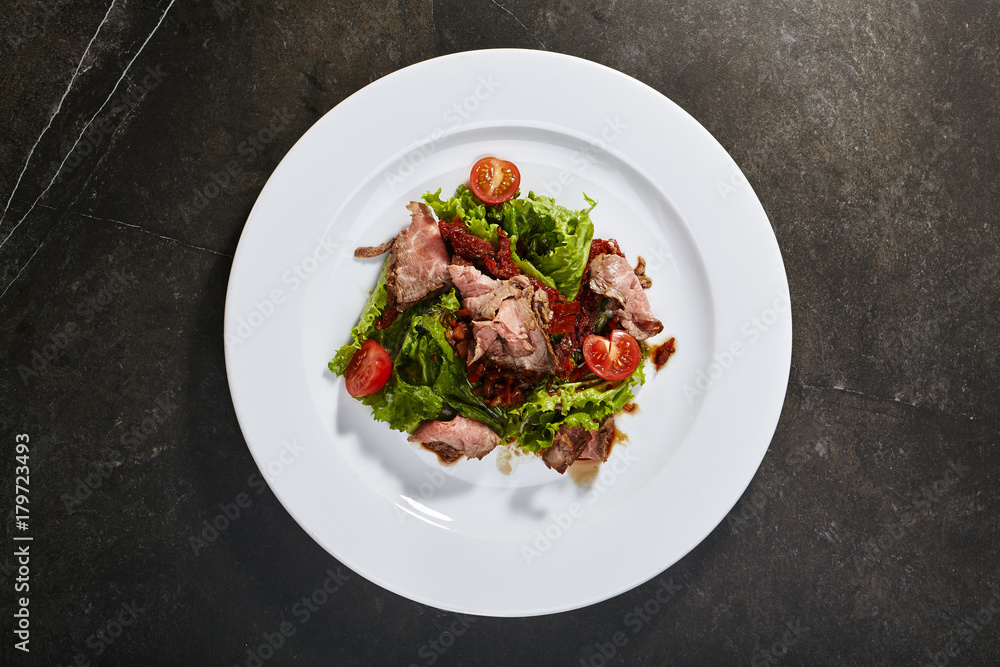 Roast beef with sun-dried tomatoes, green salad and fresh tomatoes Roast beef with sun-dried tomatoes, green salad and fresh tomatoes