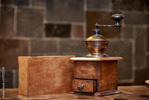 An old coffee grinder with a wooden box