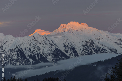 Aufnahme der Kanzelwand im Abendlicht mit von der Abendsonne angestrahltem Gipfel tor glühend und Nebelschleiern im Tal aufgenommen im Winter 2013
