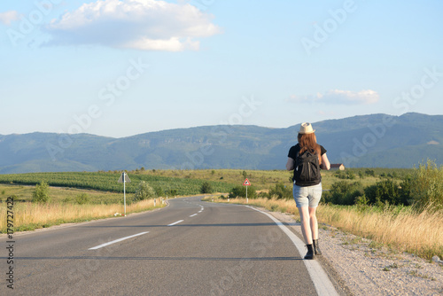 Woman Walking on the road in mountains at sunset. Forty Years old woman on the road