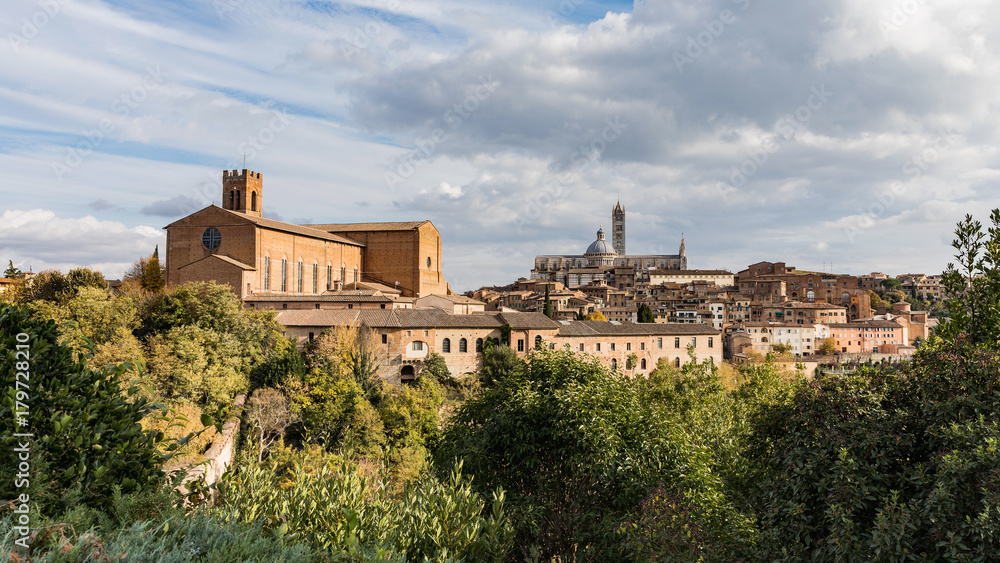 Beautiful view of Dome and campanile of Siena Cathedral, Duomo di Siena, and Old Town of medieval city of Siena in the sunny day. Tuscany, Italy.