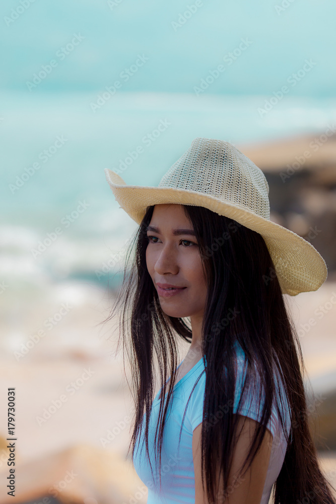 portrait young asian woman wear hat posing on the beach 