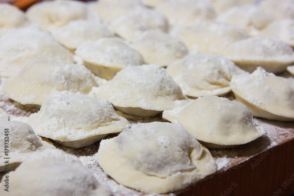 dumplings in flour on the table. Raw dumplings with handmade meat close-up. dumplings in flour on the table. Raw dumplings with handmade meat close-up.