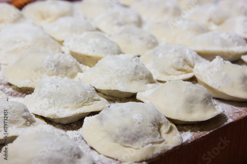 dumplings in flour on the table. Raw dumplings with handmade meat close-up.